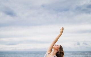 Frau macht Yoga am Meer