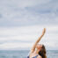 Frau macht Yoga am Meer