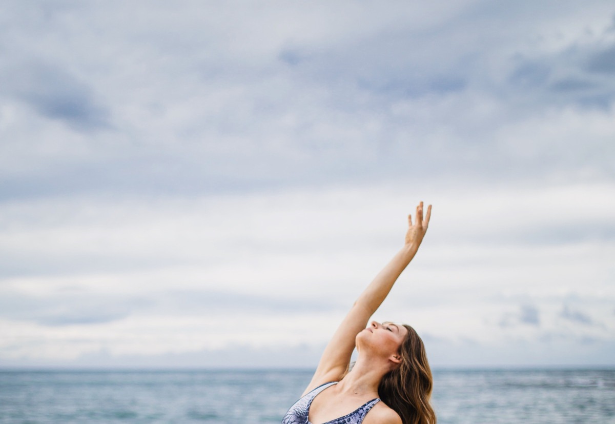 Frau macht Yoga am Meer