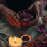 Hände, Kerze und Blüten